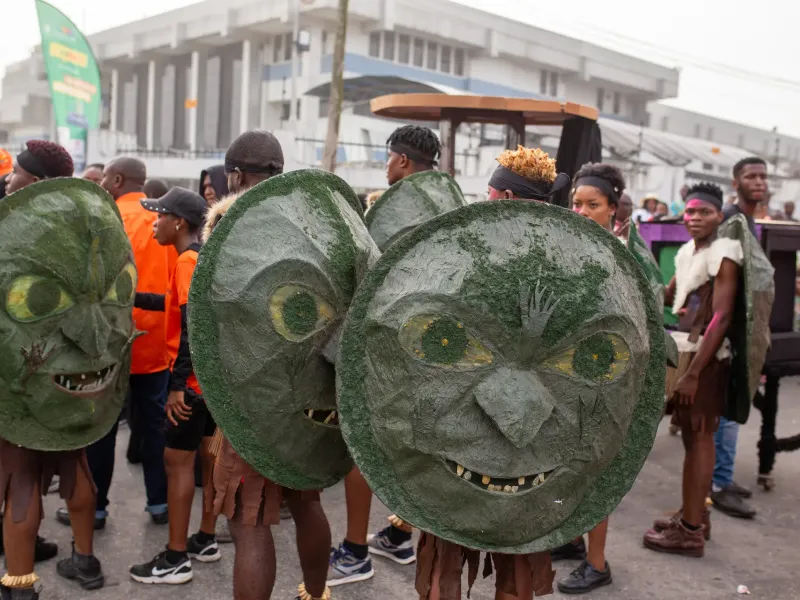 Performers in large carved masks among the crowd on a Calabar street during the carnival in Cross River State, Nigeria.