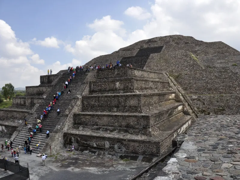 The stepped stone terraces of the Pyramid of the Moon at Teotihuacan in Mexico, visitors climbing the central stairway