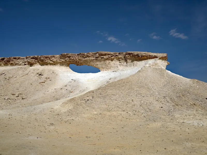 Wind eroded limestone rising from flat desert on the Zekreet peninsula in western Qatar