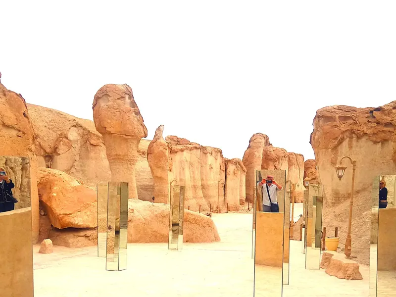 Visitors walking between the shaded sandstone clefts of Al-Qarah Mountain in the Al-Ahsa oasis, eastern Saudi Arabia.