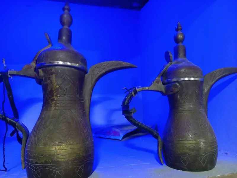 Two engraved copper dallah coffee pots of the kind used to serve Arabic coffee across the Arabian Peninsula.
