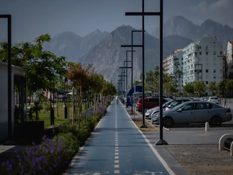A paved cycle and walking path along the coast at Antalya, Turkey, with the Taurus mountains rising behind the town.