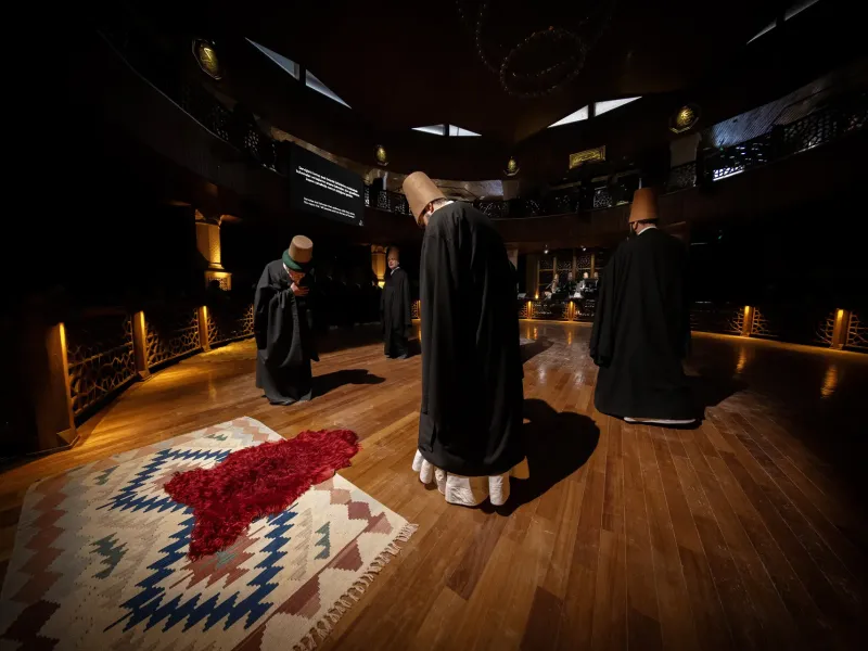 Dervishes in white robes and tall felt hats turning during the sema ceremony in Konya, Turkey.