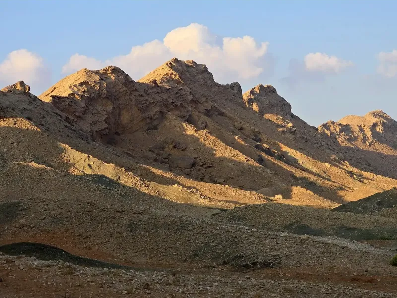 The low rocky ridge of Jebel Faya in Sharjah rising from open gravel desert