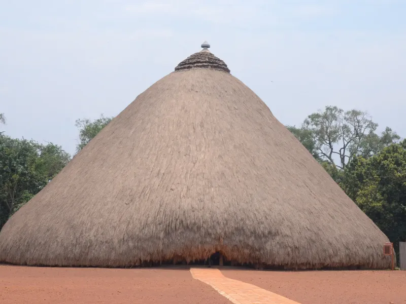 The large domed thatched tomb at the Tombs of Buganda Kings at Kasubi in Kampala, Uganda, on a swept earth apron.