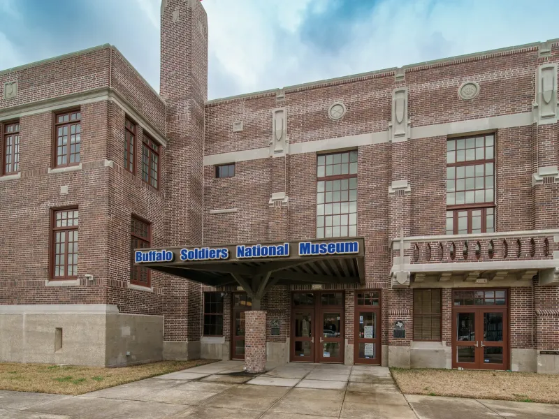 The brick entrance of the Buffalo Soldiers National Museum in Houston with its name on the canopy.