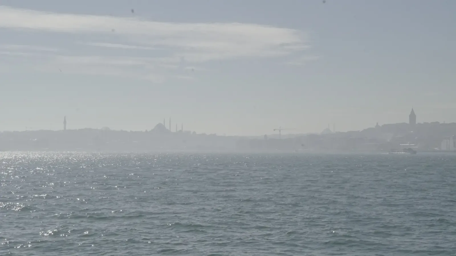 The Bosphorus at Istanbul, Turkey, on a hazy day, the domes and minarets of the old city faint on the far shore.