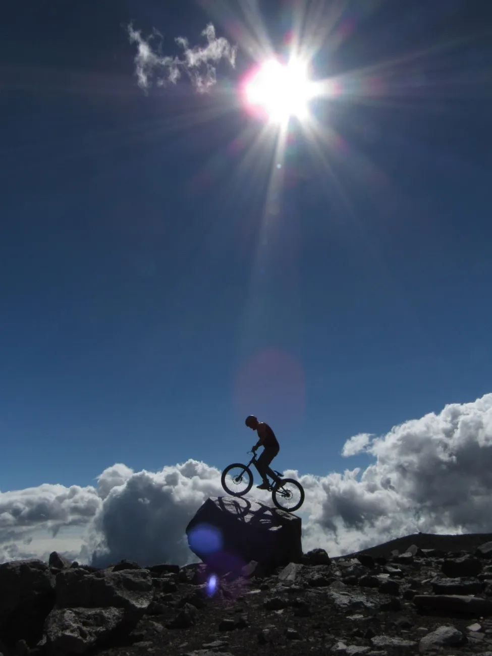 Trials bicycle balancing on a large rock