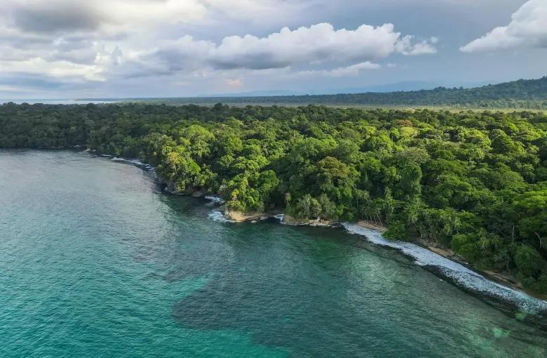 Forested coastline enclosing a calm turquoise lagoon in Costa Rica.