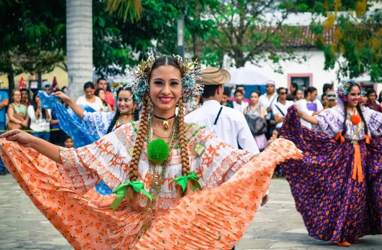A dancer in traditional Costa Rican dress with a wide skirt at a street parade.