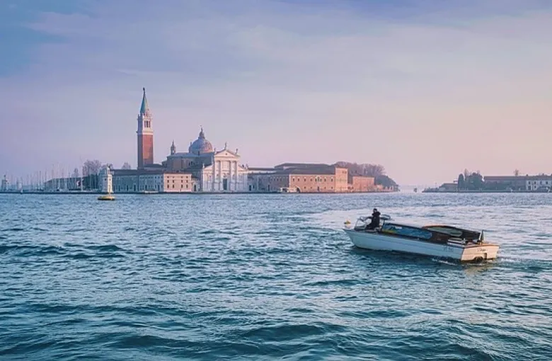 The island church of San Giorgio Maggiore across the Venetian lagoon, with a boat passing