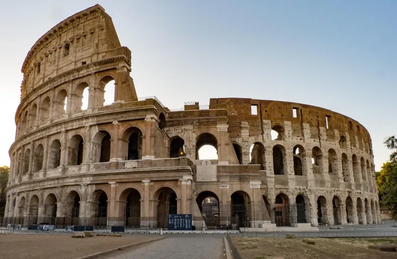 The Colosseum in Rome, its tiers of arches lit by low sun