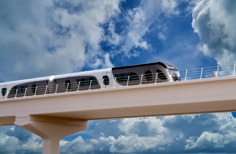 A Doha Metro train crossing an elevated track under a blue sky.