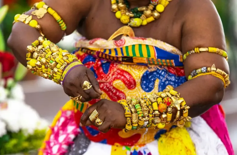 A woman dancing adowa in a traditional kente outfit in ghana during a cultural journey