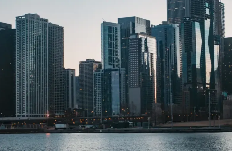 Chicago Illinois downtown skyline at dusk viewed from the waterfront with illuminated skyscrapers reflecting evening light