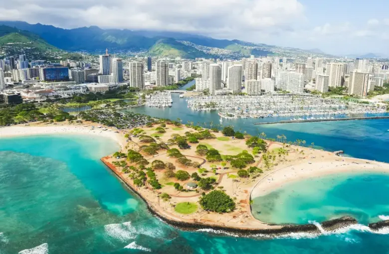 Aerial view of Honolulu harbor marina and Magic Island park; ideal backdrop for group cruises departing Waikiki.