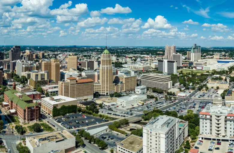 Aerial panoramic view of San Antonio Texas downtown skyline with Tower of the Americas and historic buildings under blue sky
