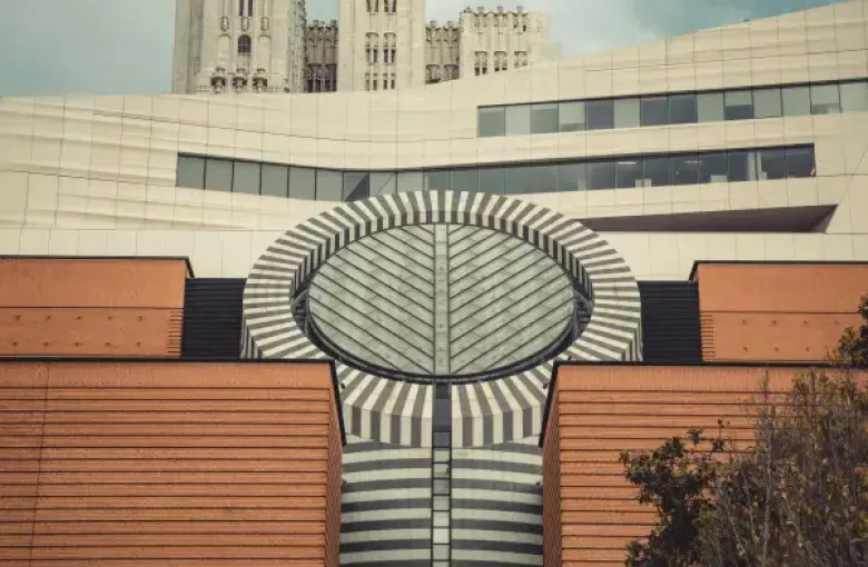 SFMOMA's striped cylindrical skylight rises above red brick facade with Gothic towers of a historic san-francisco-ca build...