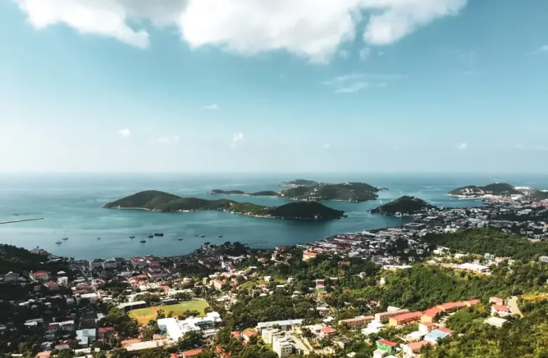 Aerial view of Charlotte Amalie harbor on St. Thomas with green hills and turquoise Caribbean water.