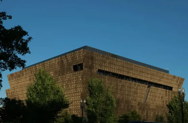 The bronze latticed exterior of the National Museum of African American History and Culture in Washington; DC; under a cle...