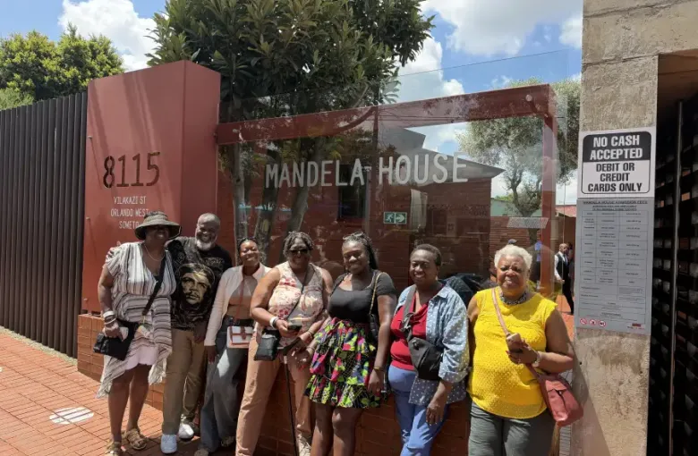 Group of seven travelers posing outside Mandela House at 8115 Vilakazi Street in Orlando West; Soweto; Johannesburg.