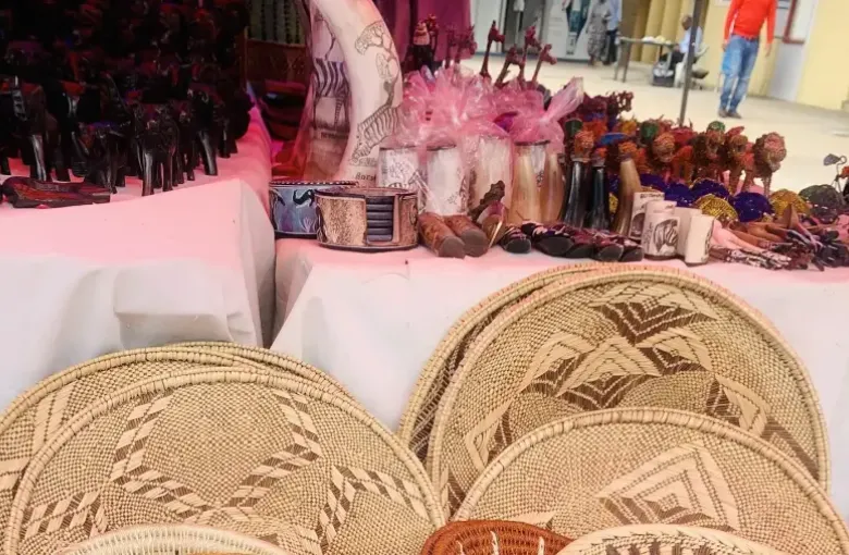 Coiled grass baskets with woven patterns displayed for sale on a market stall.