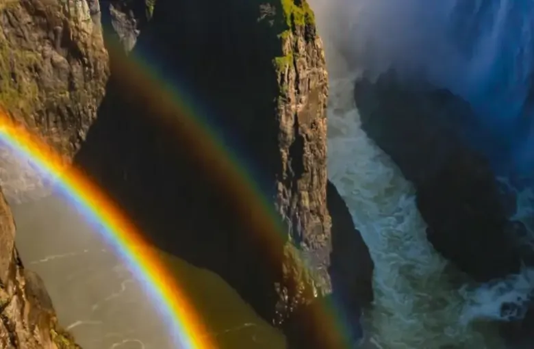 A rainbow arcs through the spray in the gorge below Victoria Falls on the Zambezi River.