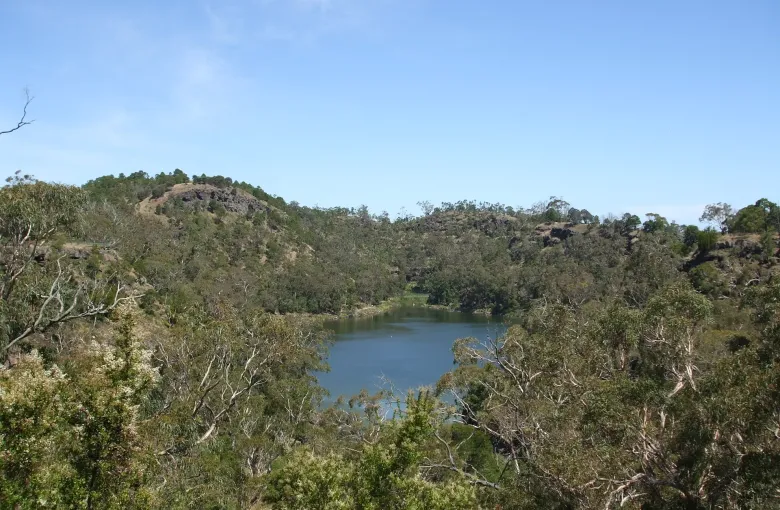 A crater lake ringed by eucalypts and old lava ridges in the Budj Bim landscape in western Victoria.