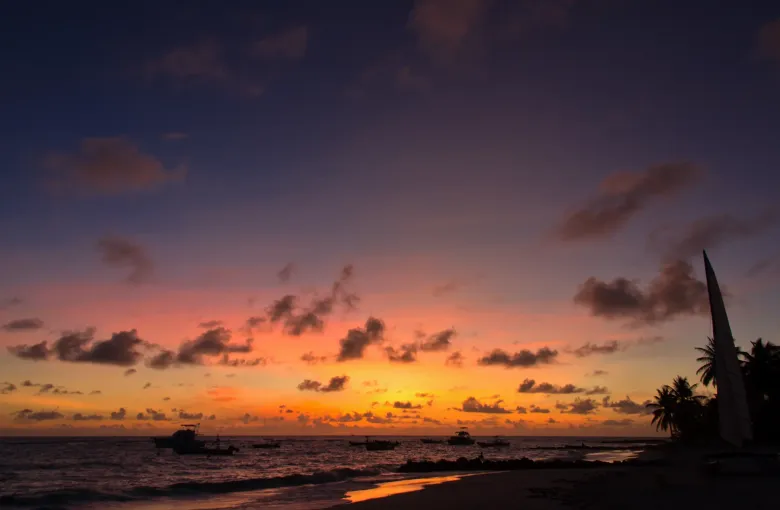 The sky glowing orange over the beach at sunset on the south coast of Barbados in Christ Church.