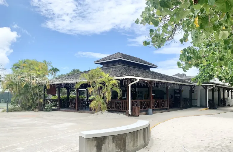 The shaded open air beach bar of the Barbados Yacht Club looking out to the sand.