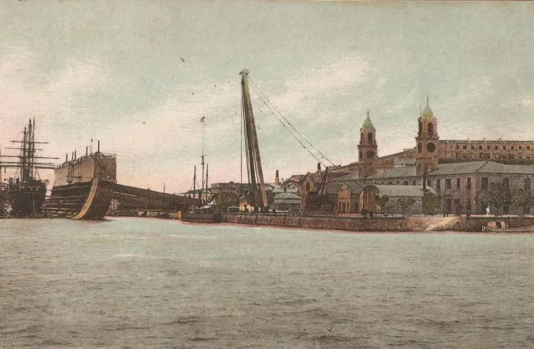 A hand-tinted postcard of about 1900 showing HM Dockyard Bermuda, its floating dock and clocktower.