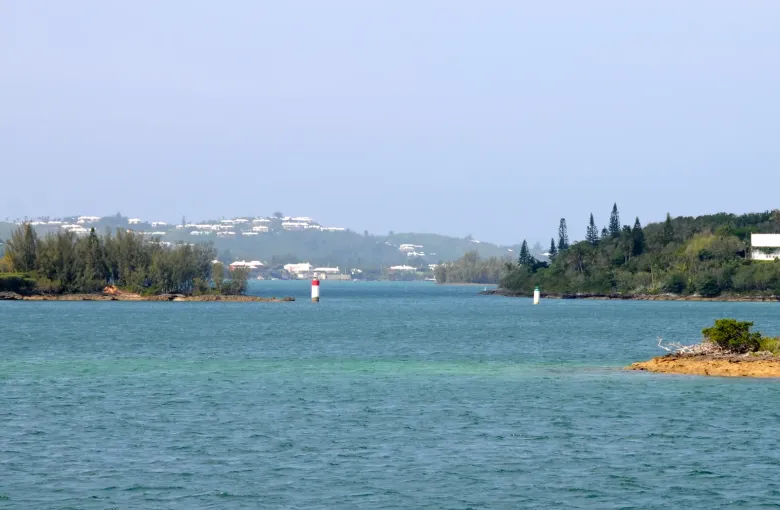 A wide view across Bermuda with Gibbs Hill Lighthouse on the ridge and houses scattered below.