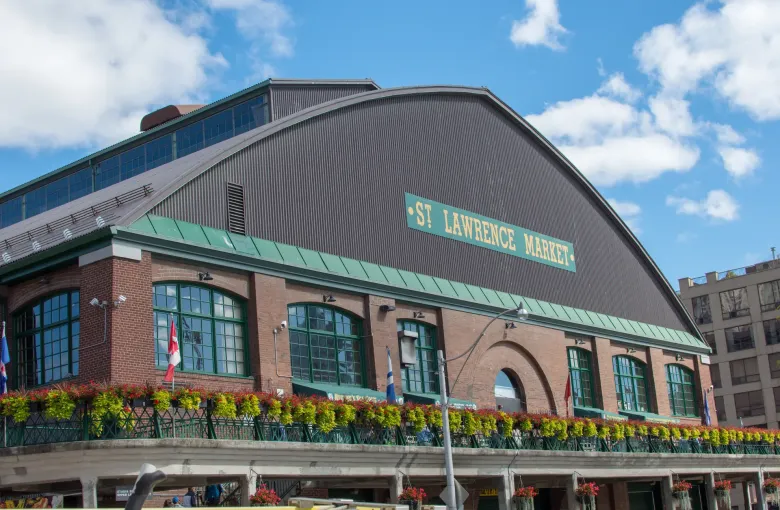 The brick and green trimmed market hall with its name lettered on the curved roof and flower boxes along the terrace.