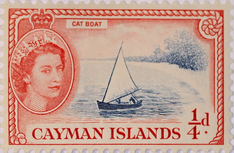 A red 1950 Cayman Islands quarter-penny stamp captioned CAT BOAT, showing a single-masted catboat under sail.