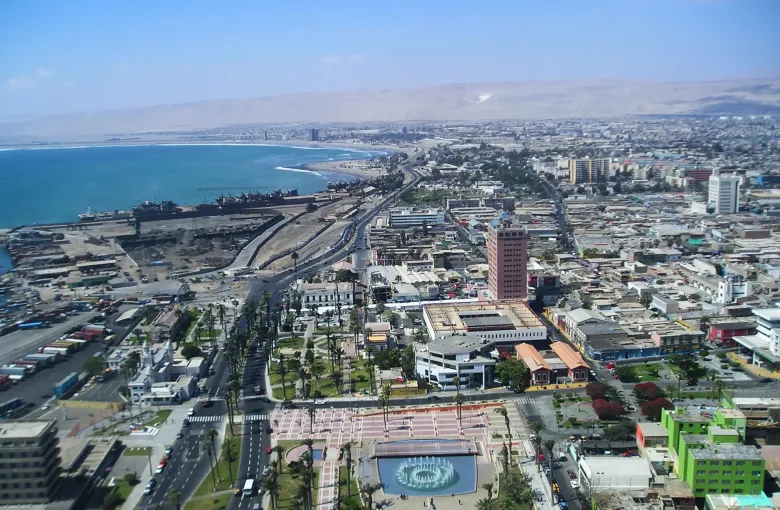 The city of Arica along its bay with the Pacific on one side and the bare hills of the Atacama rising behind it.