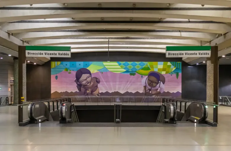Escalators descending from the concourse at Quinta Normal station in Santiago, with direction signage above and a tiled mural behind.