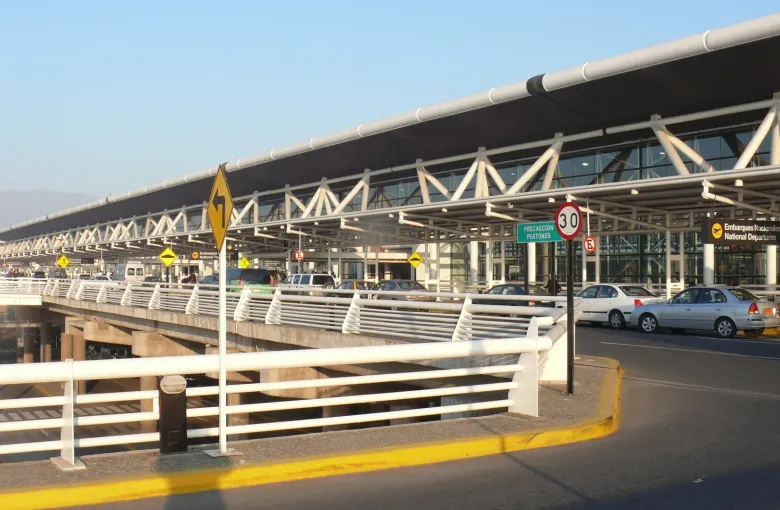 The glazed frontage and canopy of the departures level at Santiago's international airport, with signage for national departures.