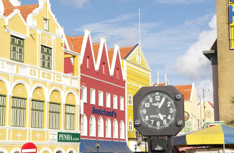 Gabled shopfronts and a street clock on a shopping street in Punda, Willemstad.