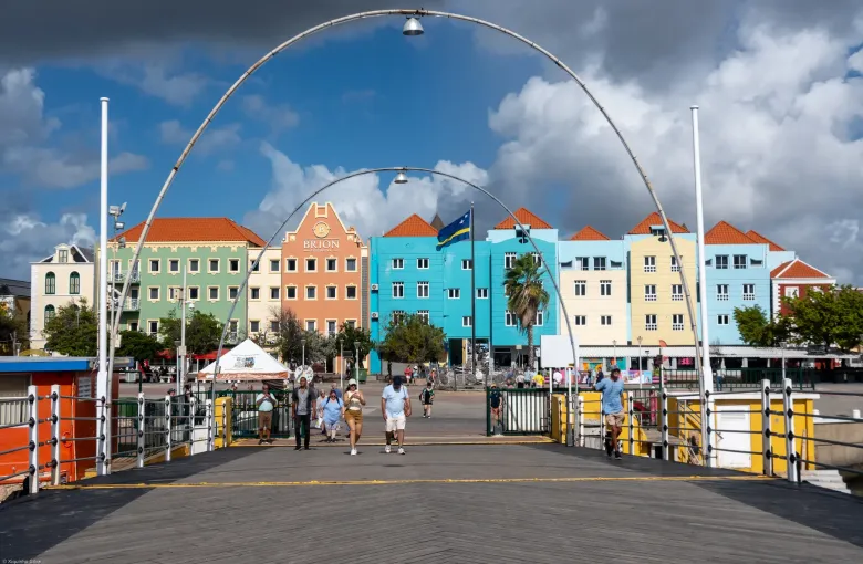 The painted gabled facades of the Handelskade along the Willemstad waterfront.