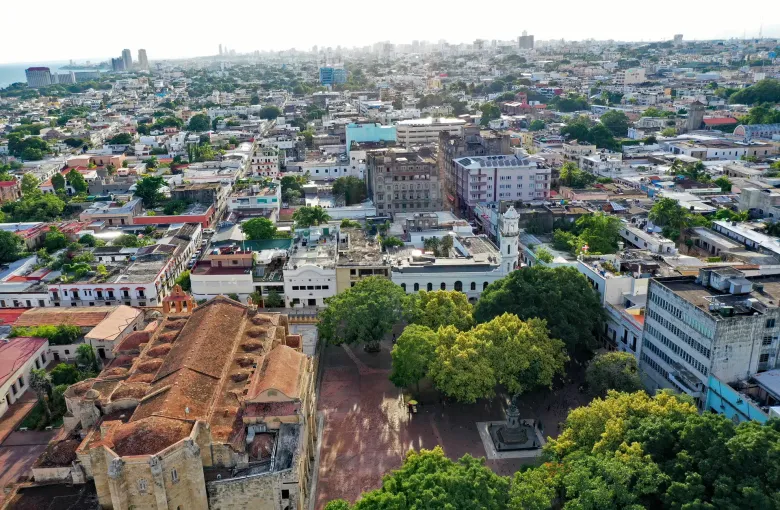Red tiled roofs and church towers of the Colonial City of Santo Domingo, with the modern city beyond.