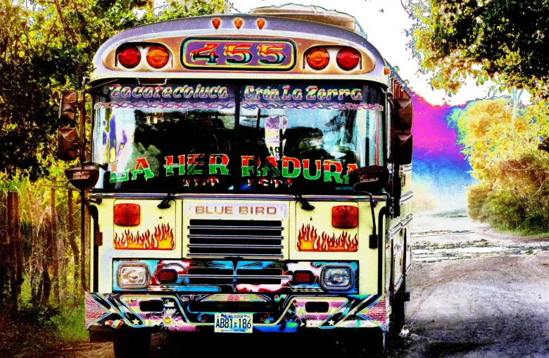 The front of a brightly painted route bus, its destination boards and flame artwork covering the bodywork.