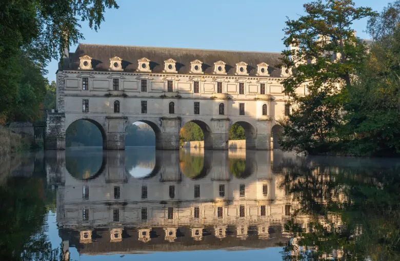 The gallery of the Chateau de Chenonceau carried on arches across the river Cher and reflected in the still water.