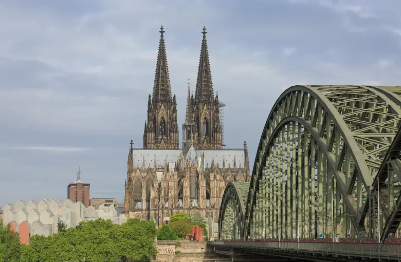 Cologne Cathedral behind the steel arches of the Hohenzollern Bridge, the busiest rail crossing into the city.
