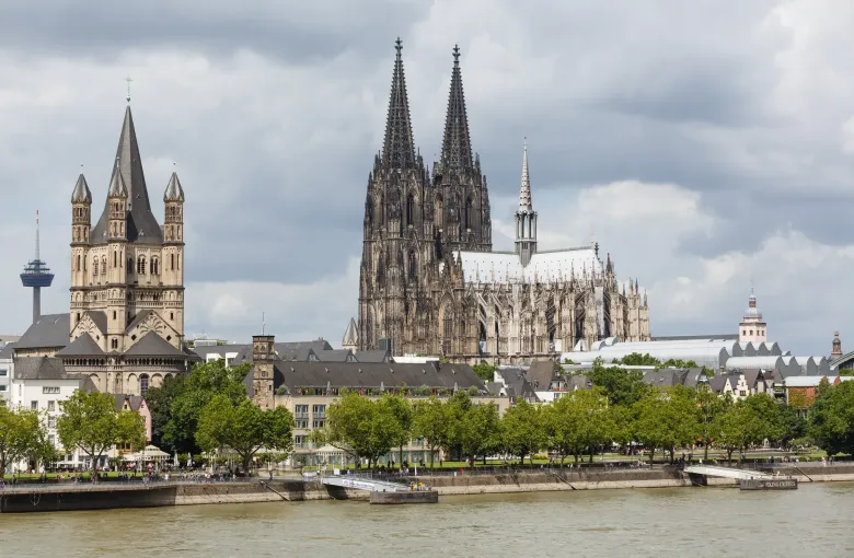 The twin spires of Cologne Cathedral rising over the old town and the Rhine embankment, with Great St Martin to the left.
