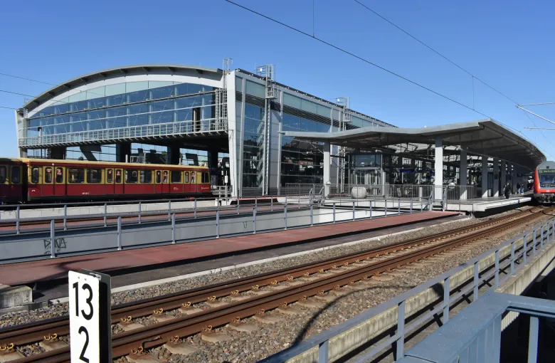A rebuilt S-Bahn platform at Berlin Ostkreuz under its arched roof, the train floor level with the platform edge.