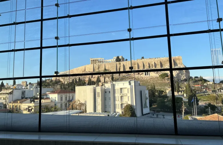 The Acropolis of Athens seen through the glass wall of the step free Acropolis Museum gallery, Greece.