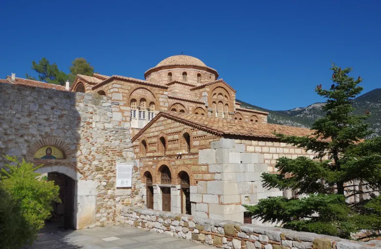 The brick and stone Byzantine church of the Hosios Loukas monastery in Boeotia, Greece, with its tiled dome.