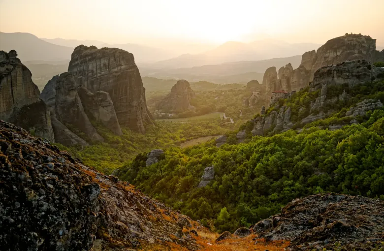 Monasteries perched on the sandstone pillars of Meteora in Thessaly, Greece, in low evening light.