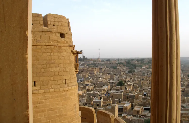 A round bastion of Jaisalmer Fort standing above the sandstone rooftops of the old city in Rajasthan.