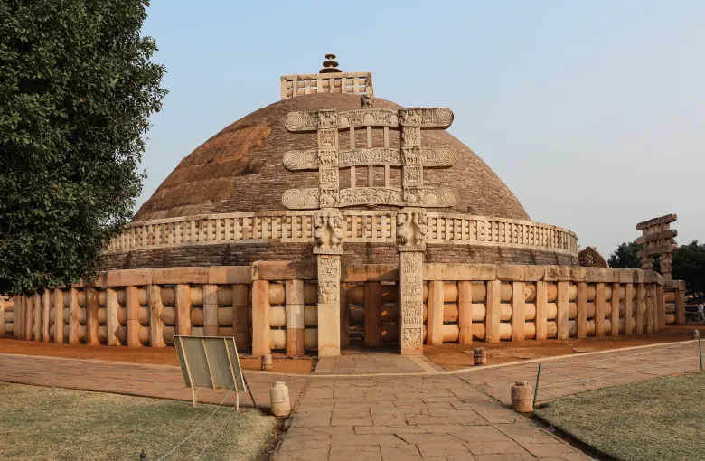 The Great Stupa at Sanchi with its carved gateway, reached across broad level paving.